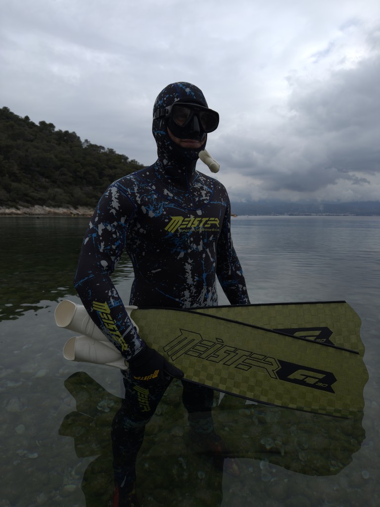 freediver meister sitting on a rock underwater