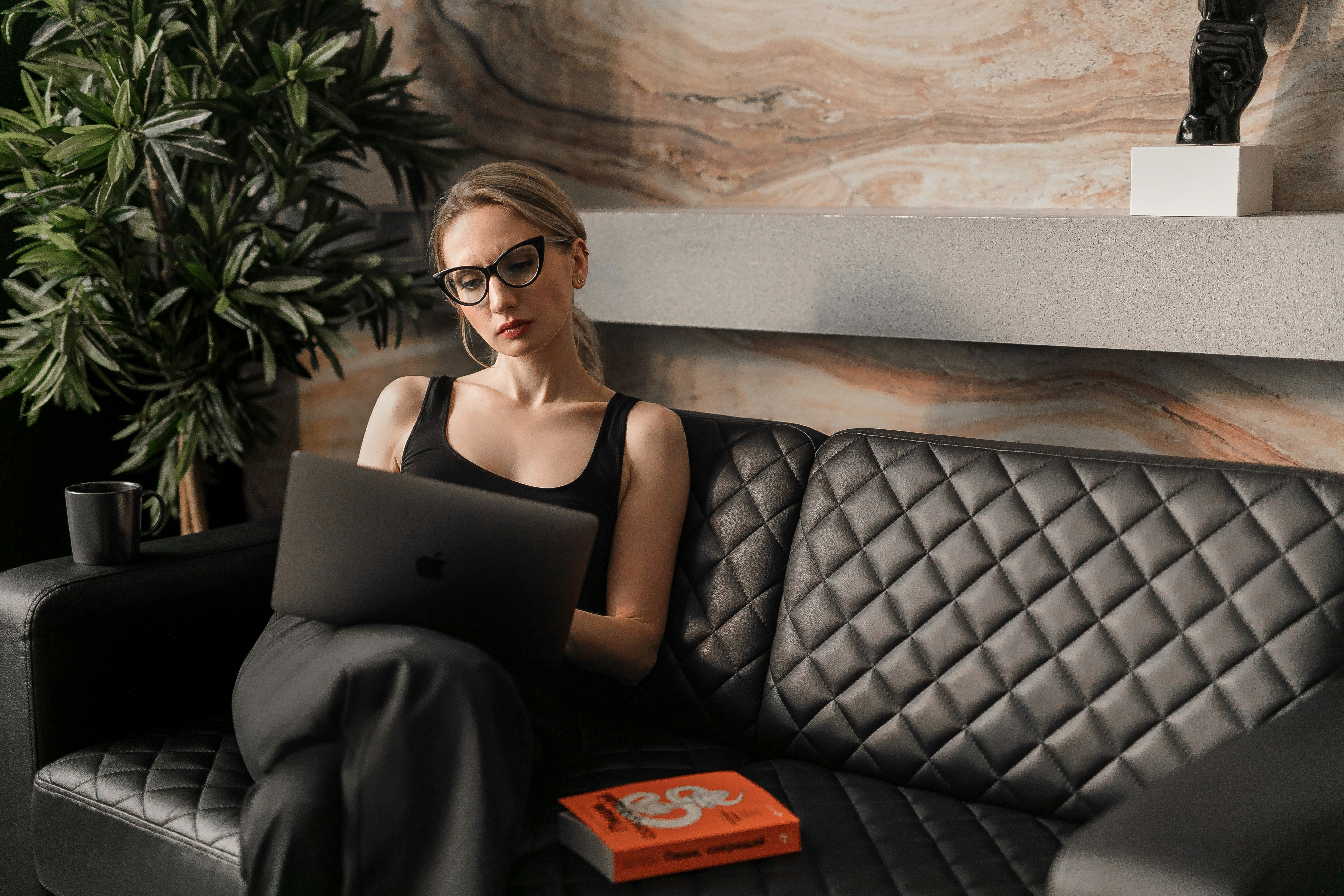 woman on couch working alone on tasty works