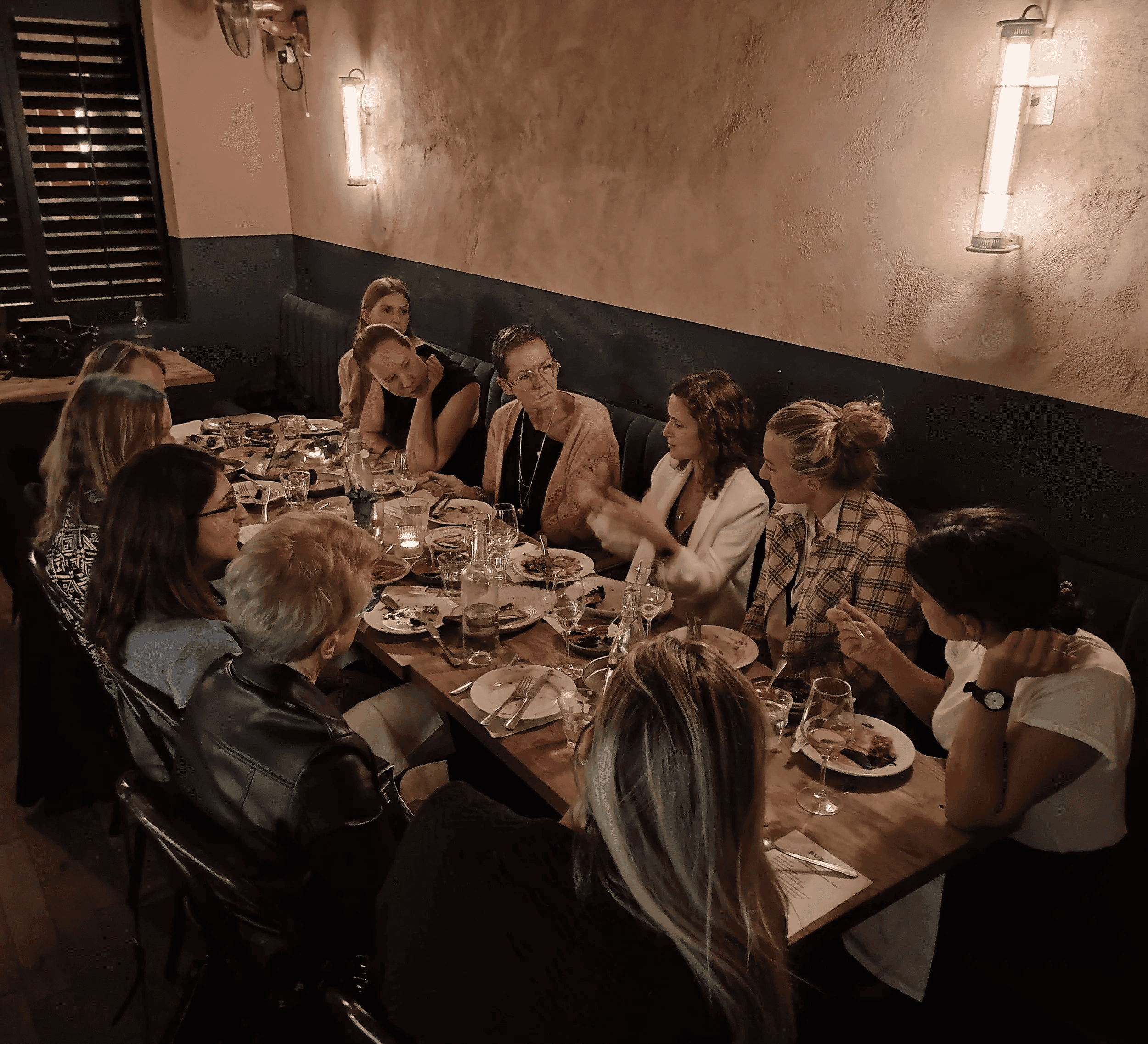 Group of women sitting around a long dinner table
