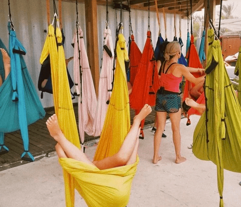 niños realizando yoga aereo en la playa