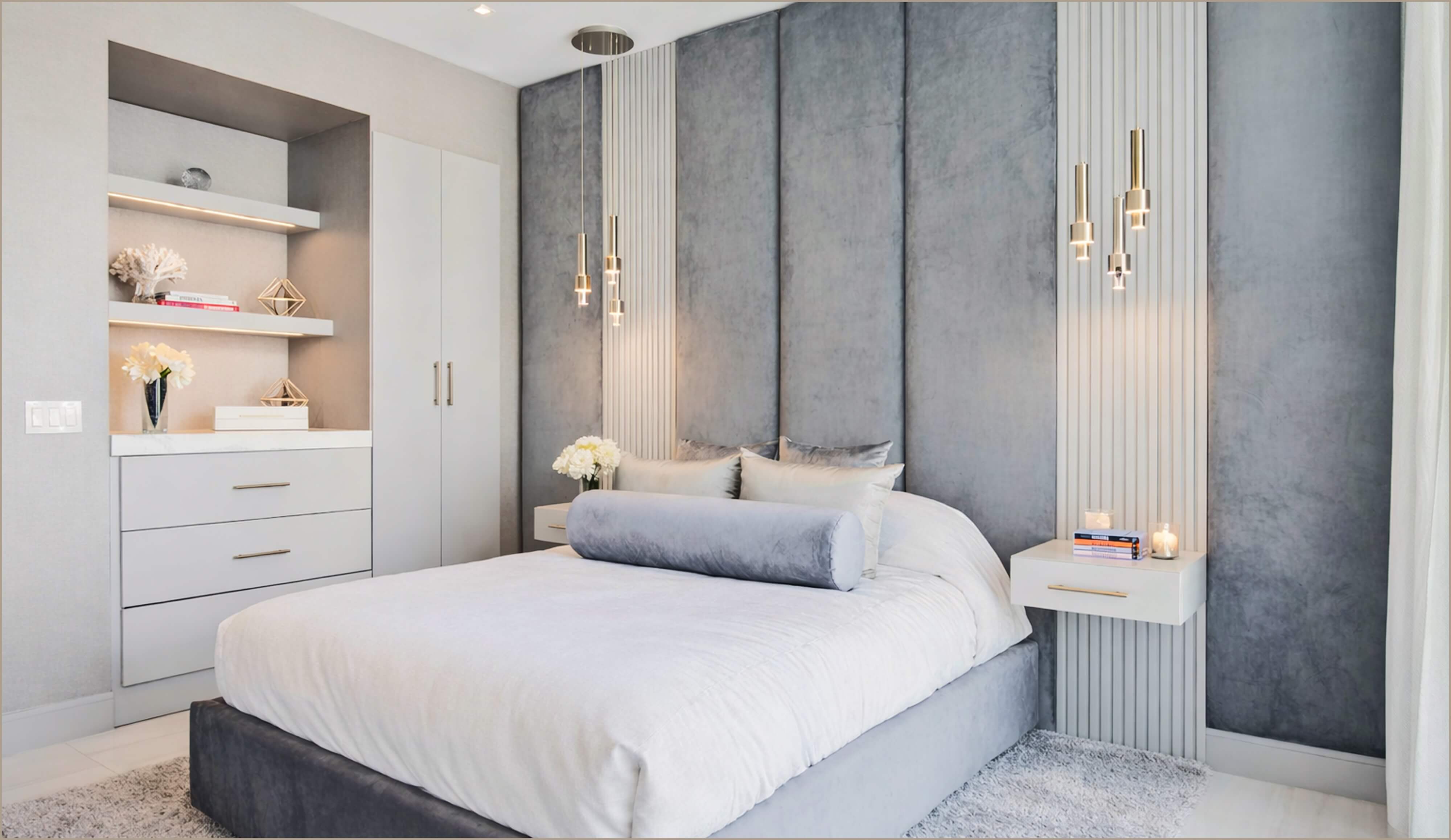 Soft contemporary bedroom with upholstered bed, paneled blue accent wall, and pendant lighting.
