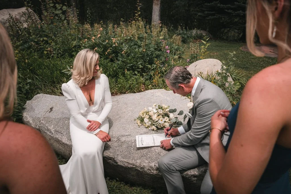 Couple signing their marriage documents outdoors