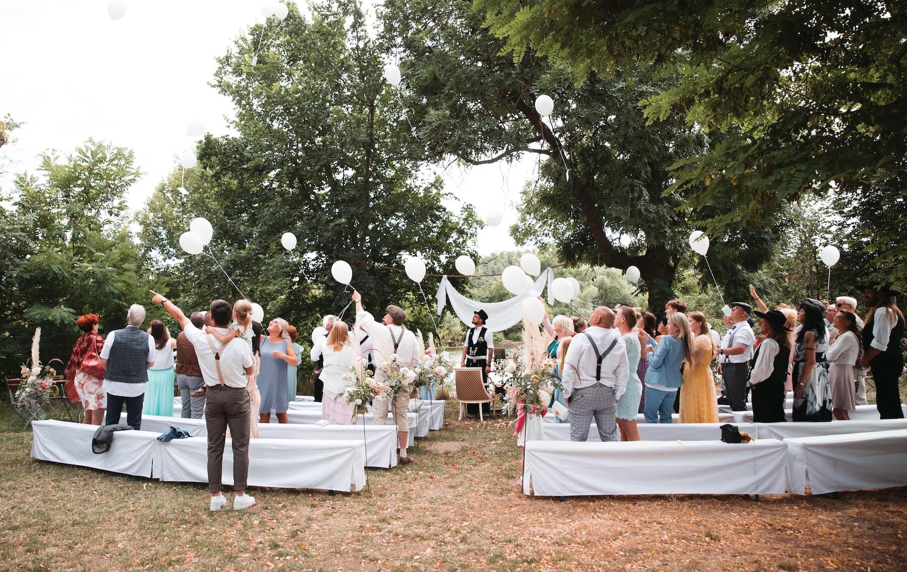 Ein glückliches Brautpaar und eine Freundin posieren für ein Hochzeitsfoto mit "Together"-Dekoration.