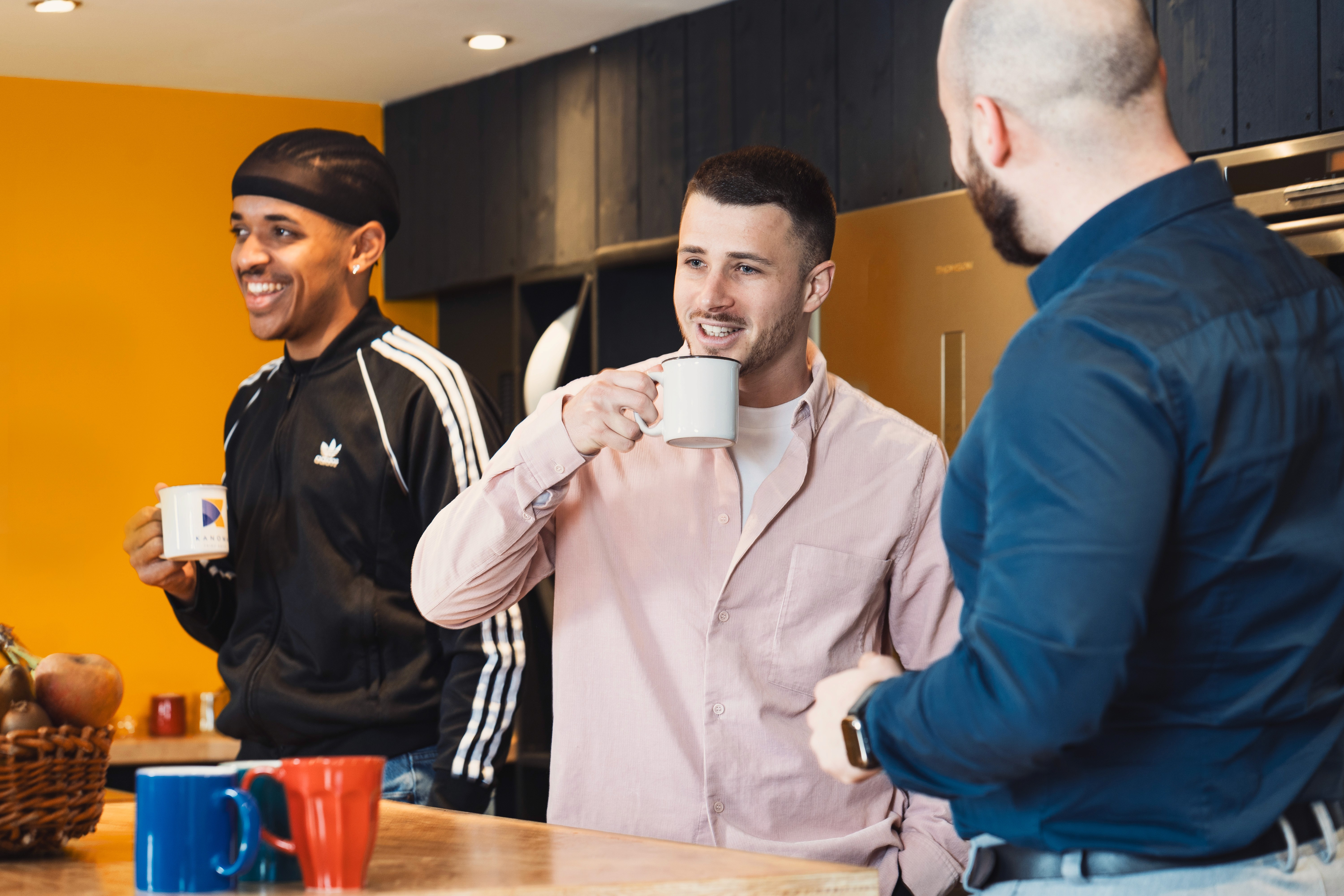 trois personnes qui discutent et prennent le café