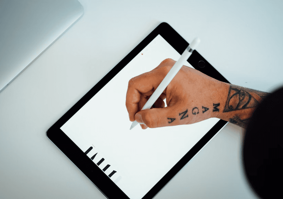 Person writing or drawing on an iPad with an Apple Pencil