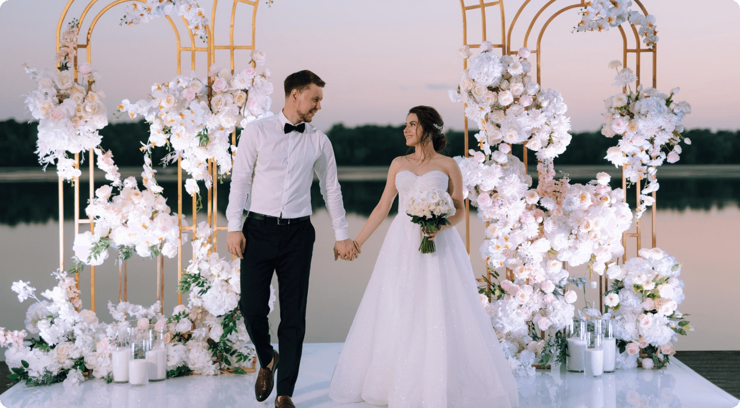 South Asian couple sitting on a swing surrounded by floral decor