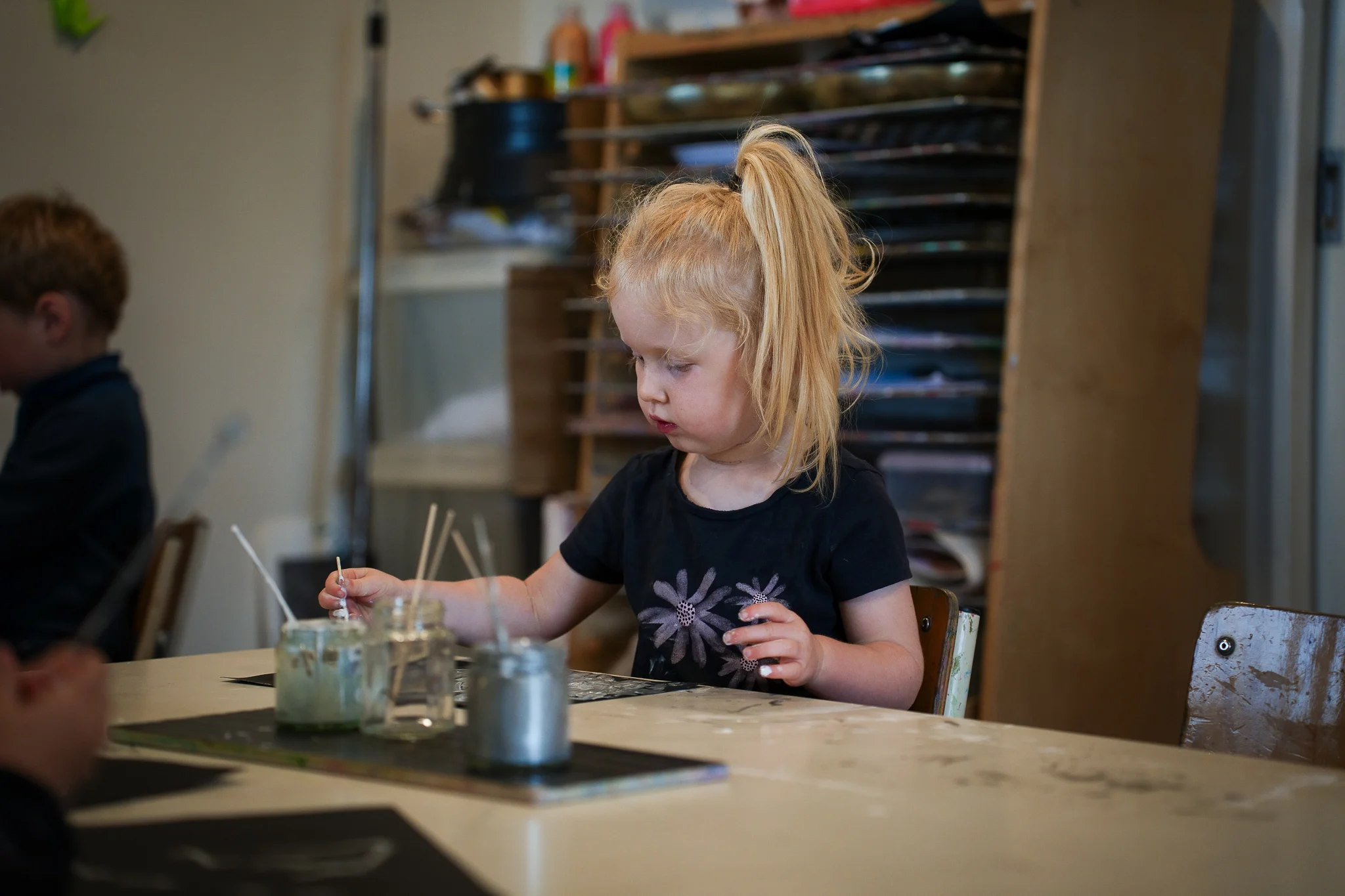 A young boy outside playing with a red ball
