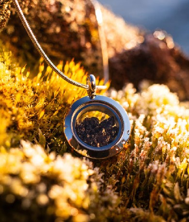 A handcrafted obsidian necklace, produced by Lava Show, displayed on a black bust. Made from real volcanic glass formed by rapidly cooling rhyolite lava, this striking piece is one of the exclusive products available at the Lava Show.