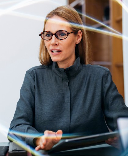 A professional woman in glasses leadng a meeting with a tablet, highlighting collaborative time management for companies and effective team communication in a business setting.