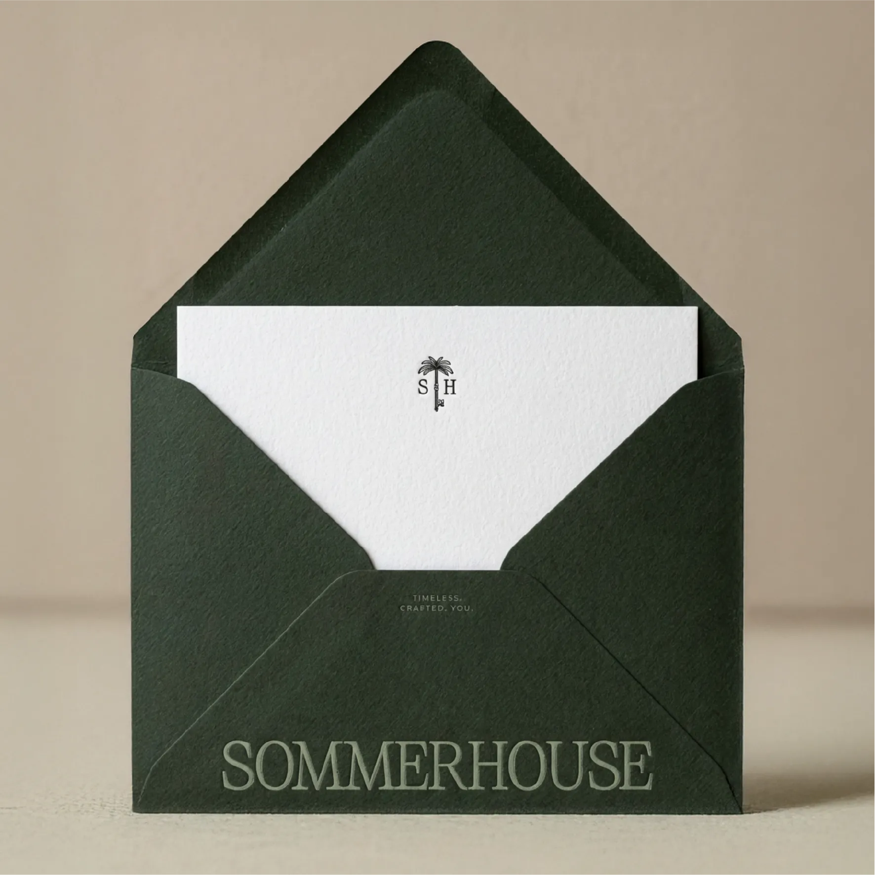 A dark green envelope, with a white letter poking out. The wordmark and submark are printed on both pieces.