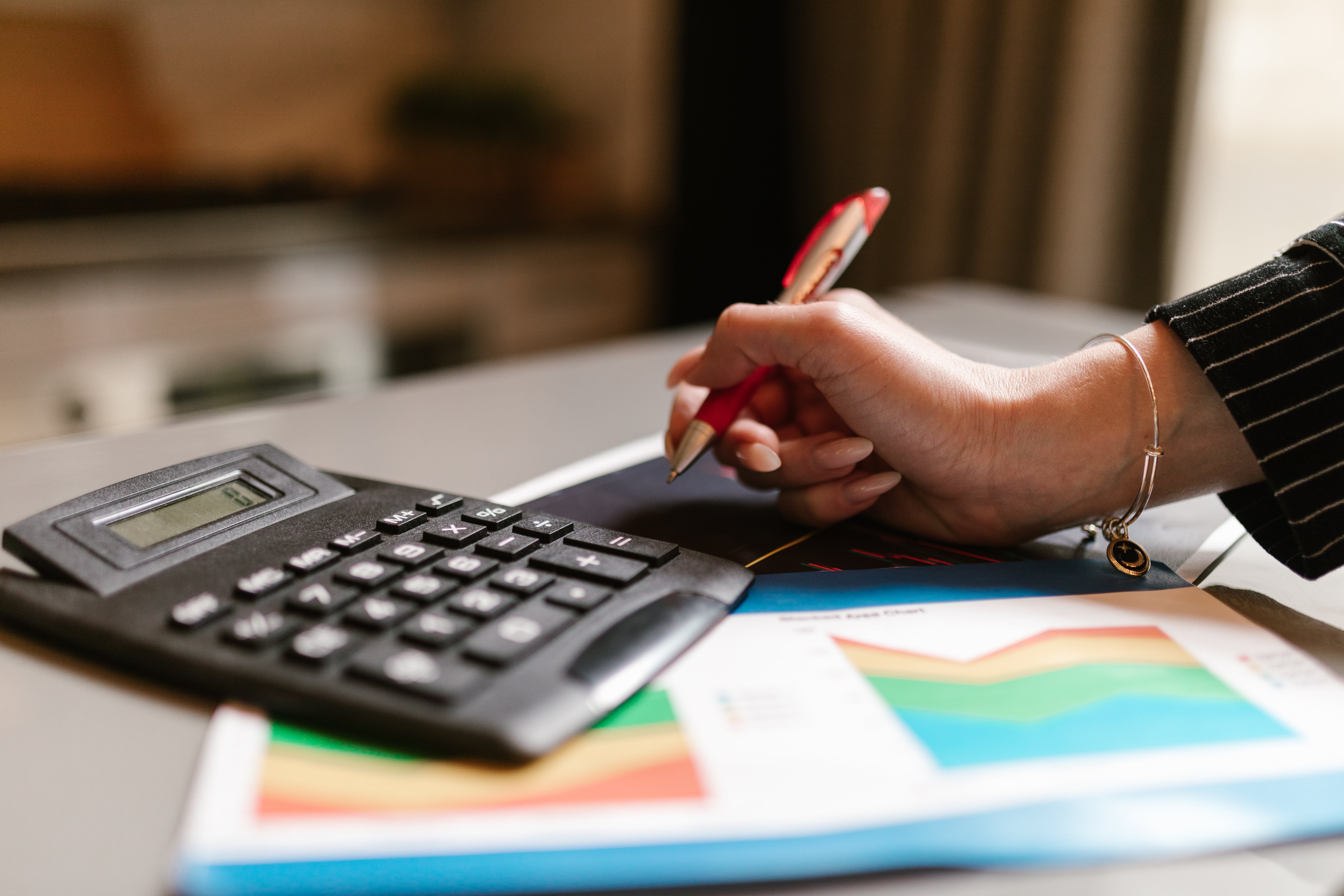 A person holding a pen calculating interest rate