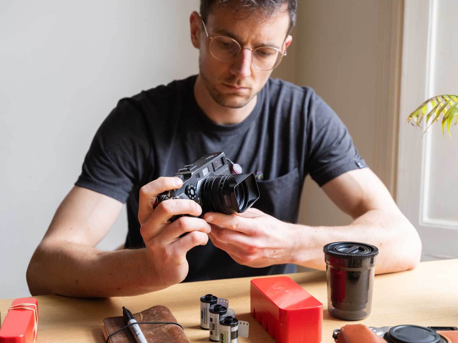 Photographer holding the Hasselblad XPan with a selection of to go film stocks for travel photography