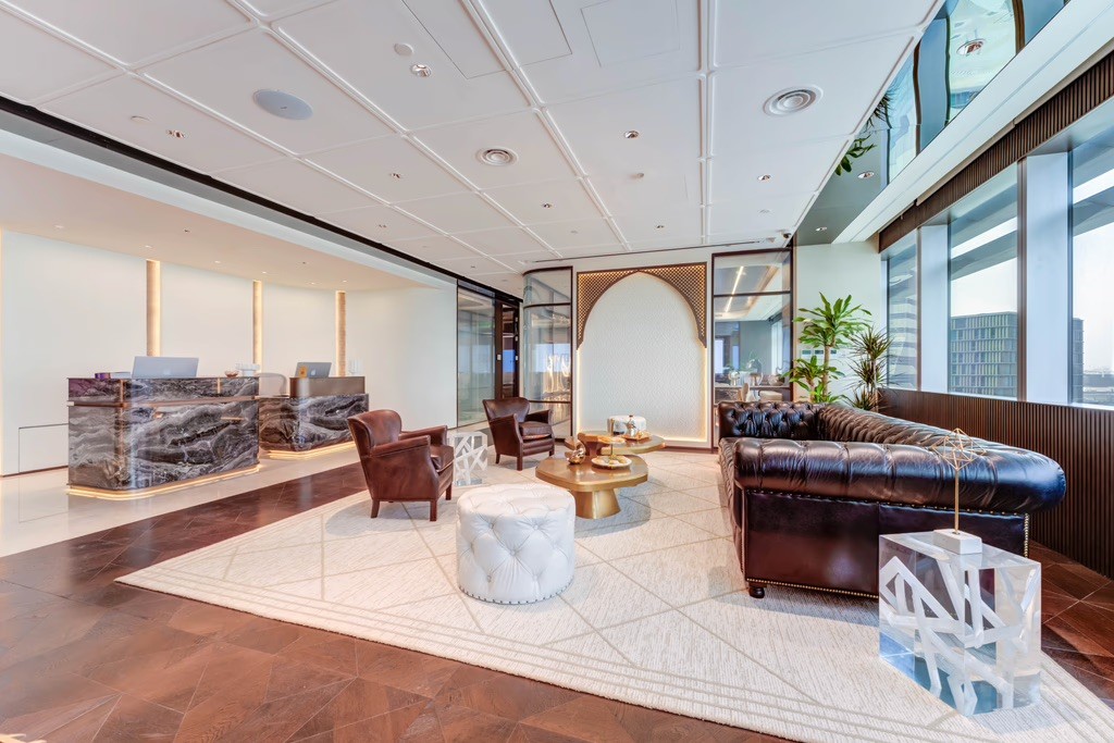 Stylish meeting room with a white table, office chairs, and integrated wall display.