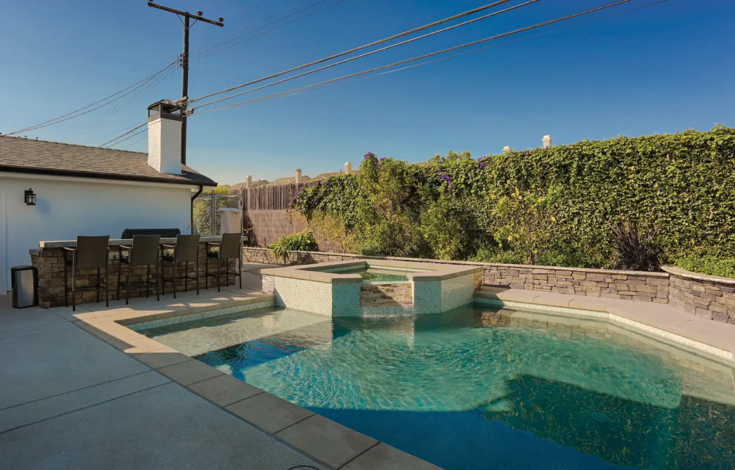 Backyard pool wtih water feature and built-in jacuzzi.  Photo by Chris Darnall.
