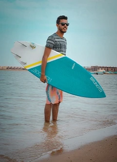 Homme avec planche de surf sur la plage