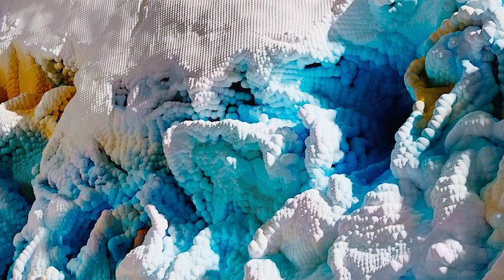 A 3D animated landscape, filled with colorful particle effects and inspired by the unique colors found in Yellowstone’s geothermal features