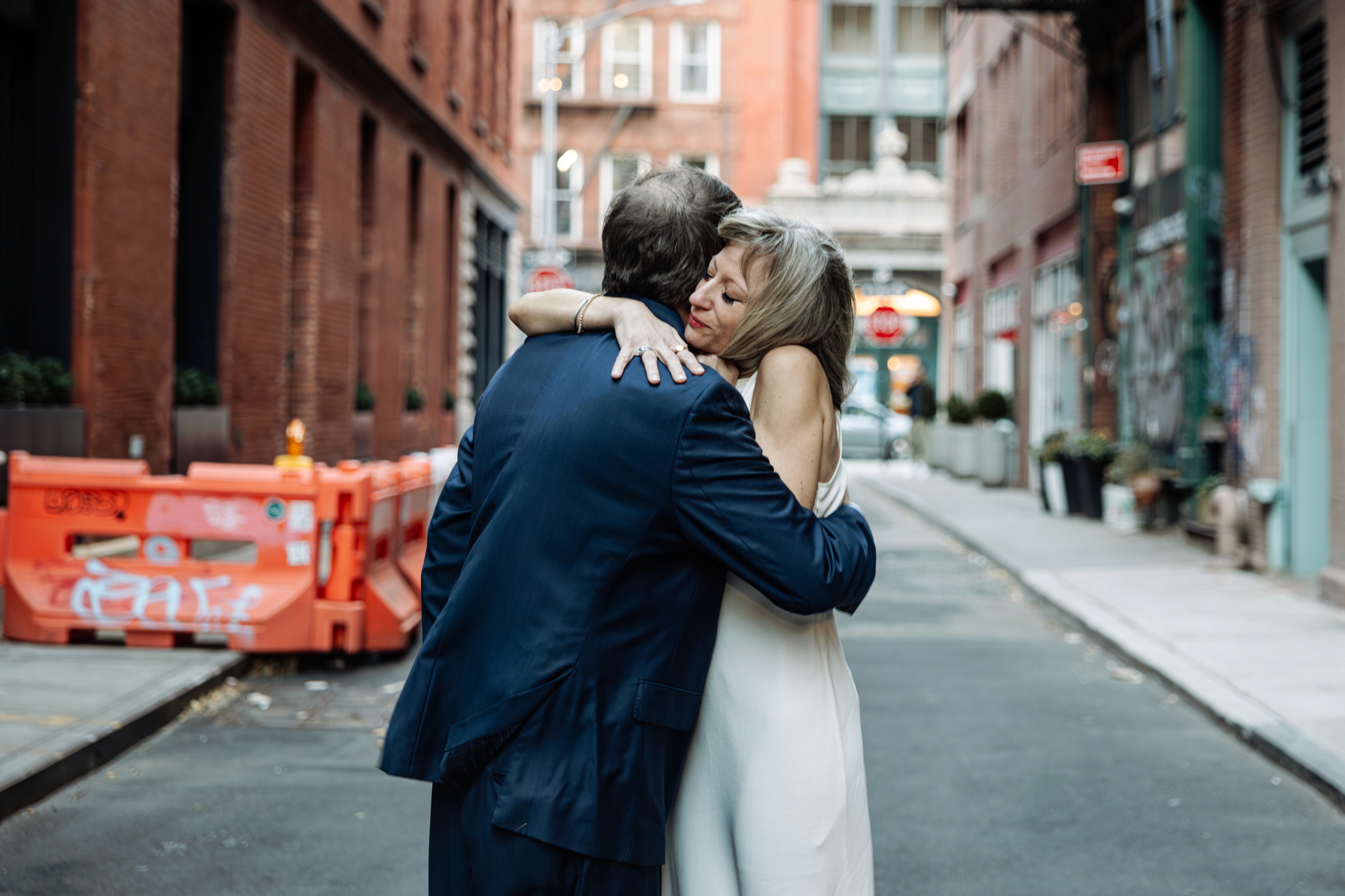 Content creator couple grinning from ear to ear, cheersing with hotdogs at the Mall in Central Park, NYC — fun, playful lifestyle and content creator photography by Lizz Spano Photography, New York City lifestyle photographer.