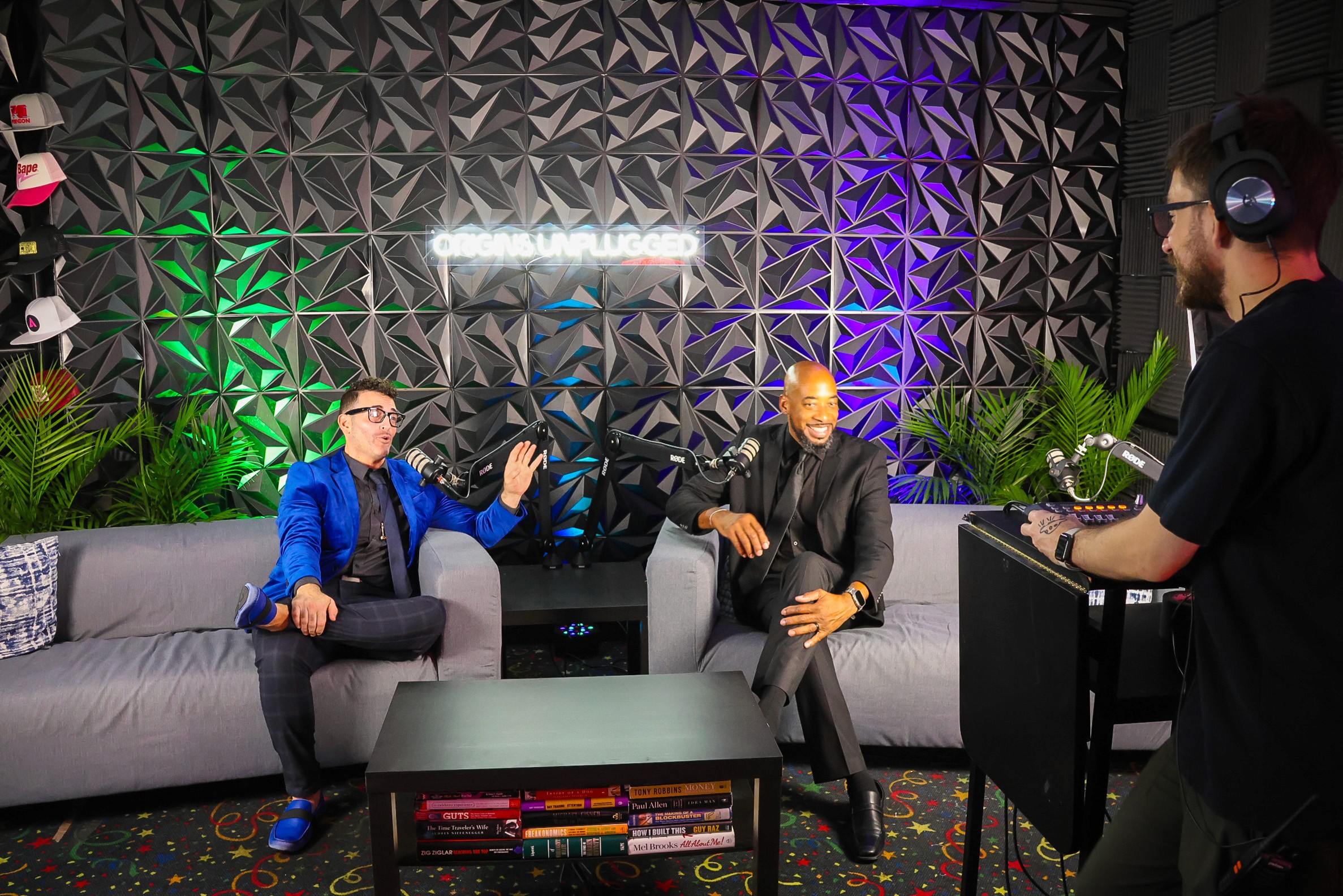 Fotoboyz Events interview set with two guests on couches while a producer monitors audio on headphones.