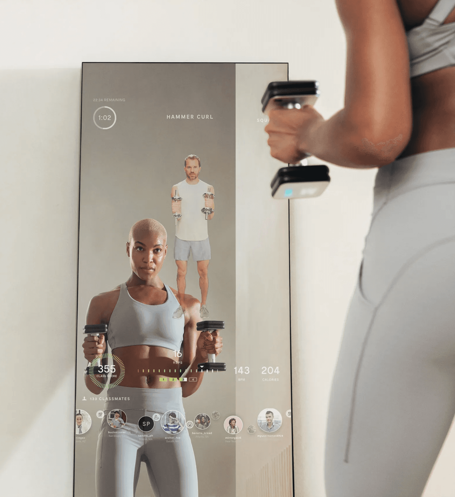 Person exercising with connected Mirror smart weights in front of a fitness mirror