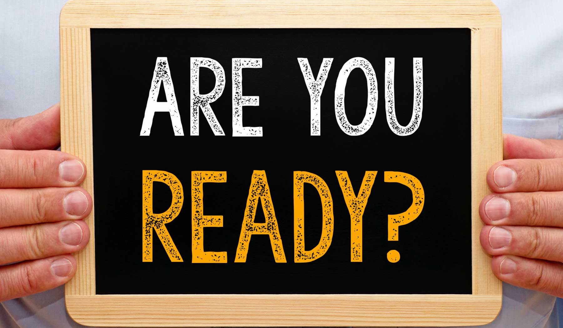 Image of a person holding a sign that says "Are you ready?".