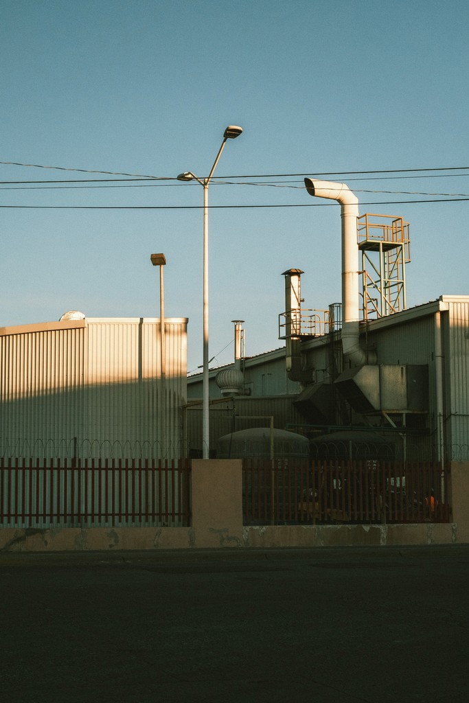 Factory exterior with smokestacks and utility poles.