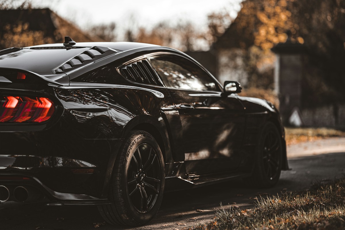 A polished black sports car on a quiet road