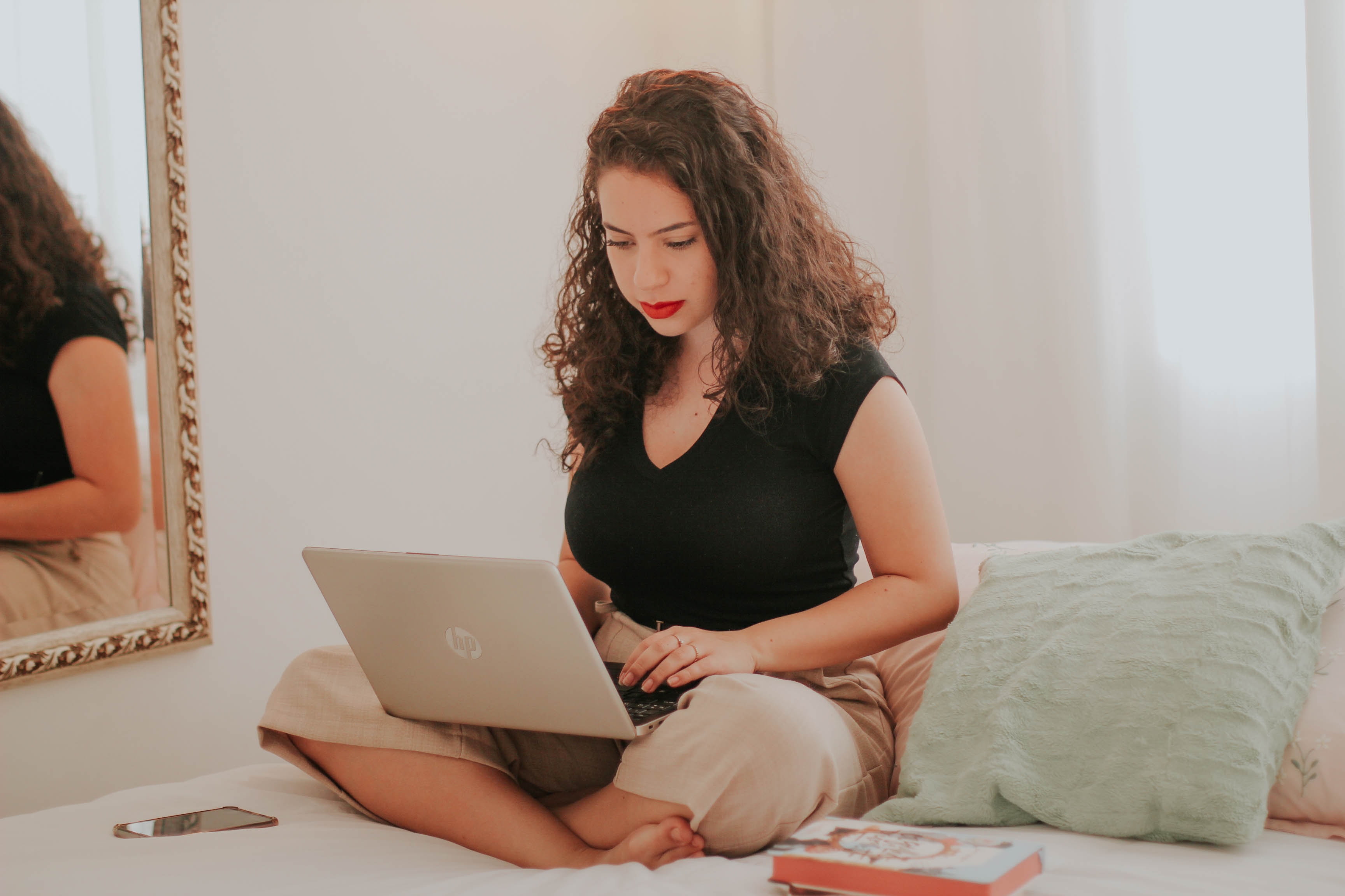 woman on bed learning gmail filter multiple email addresses