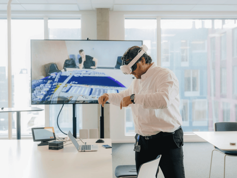 Viser en medarbejder på Trondheim byplanlægningskontor iført VR-briller og i interaktion med appen.