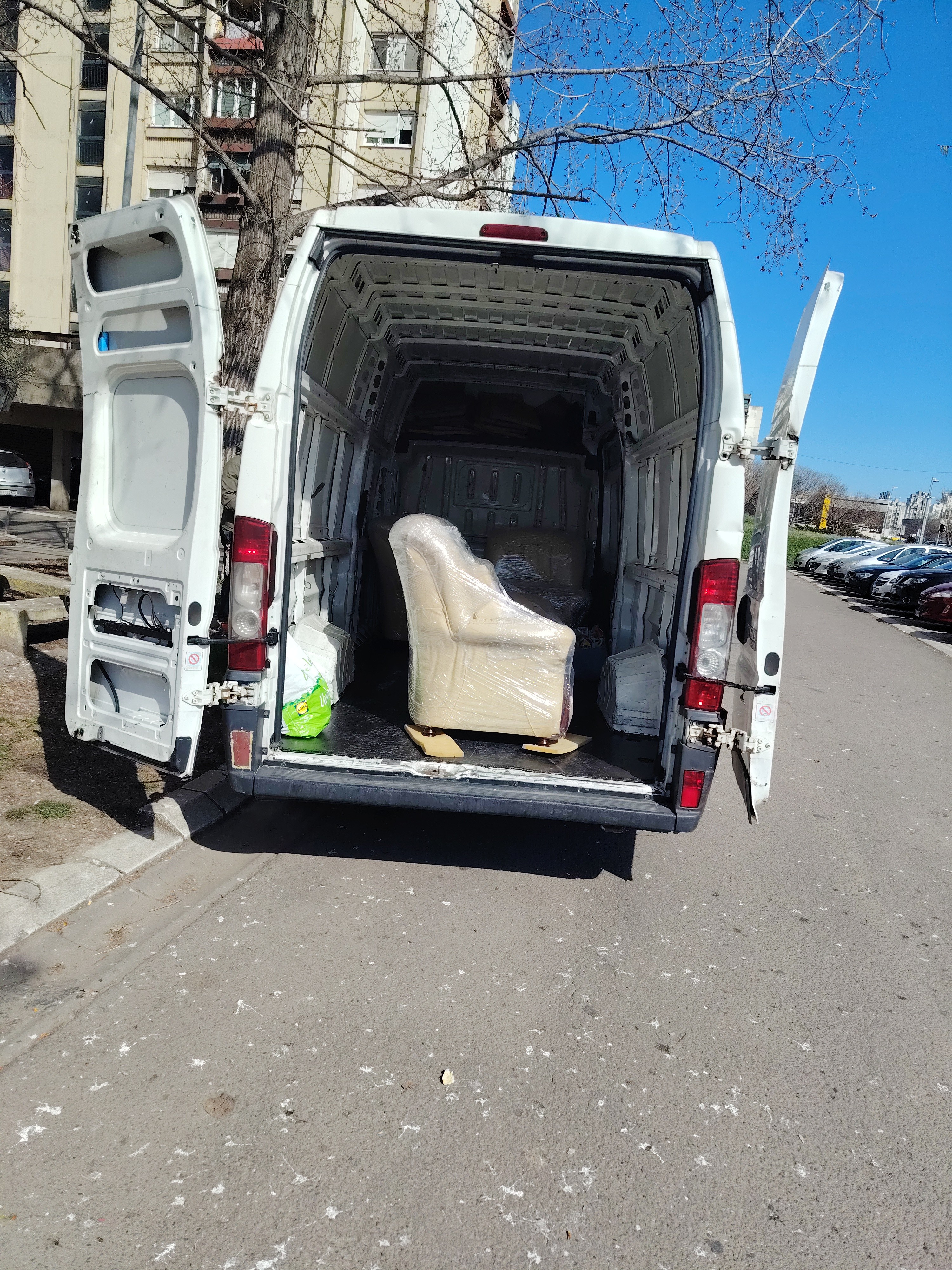 Kombi za selidbe sa otvorenim vratima i upakovanim foteljama spremnim za transport.