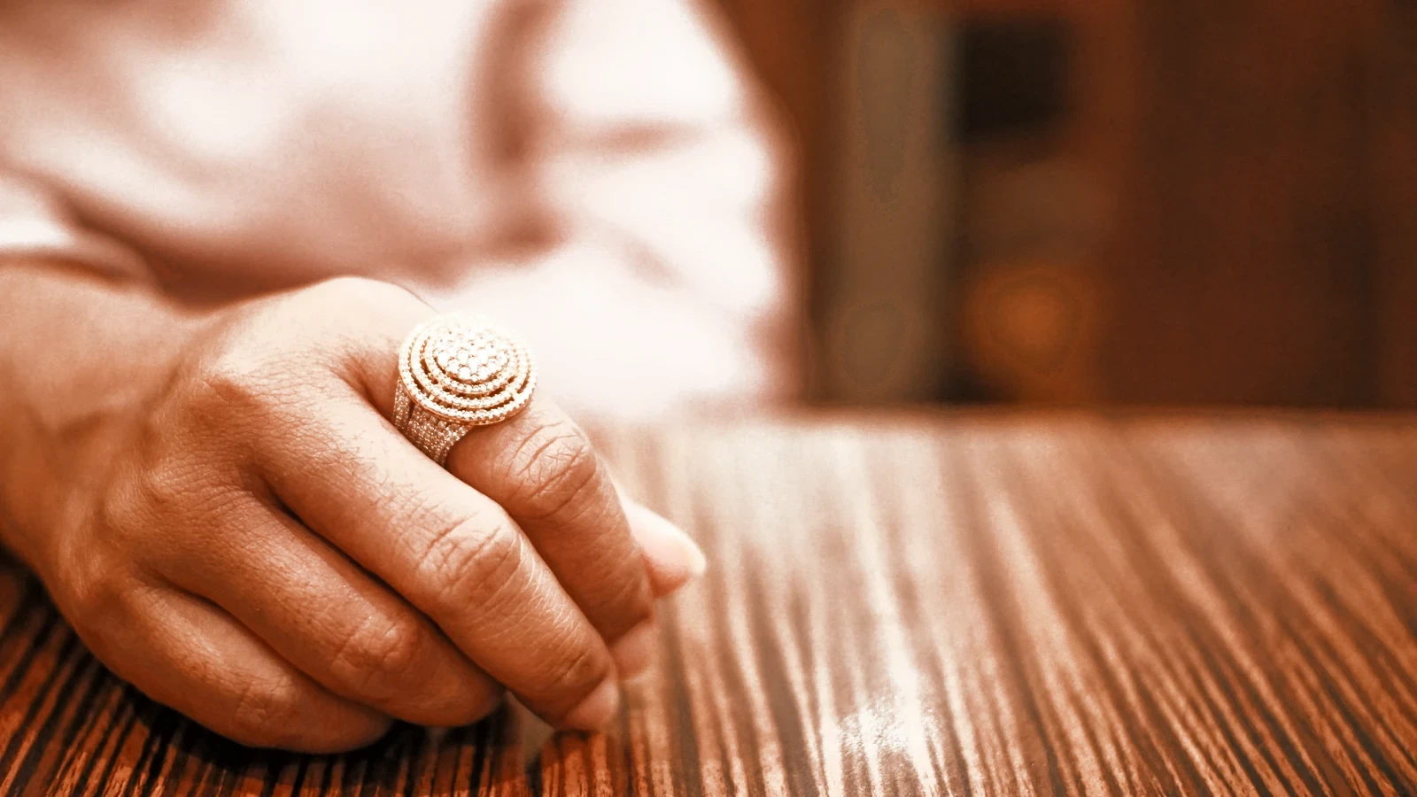 A hand wearing a gold ring