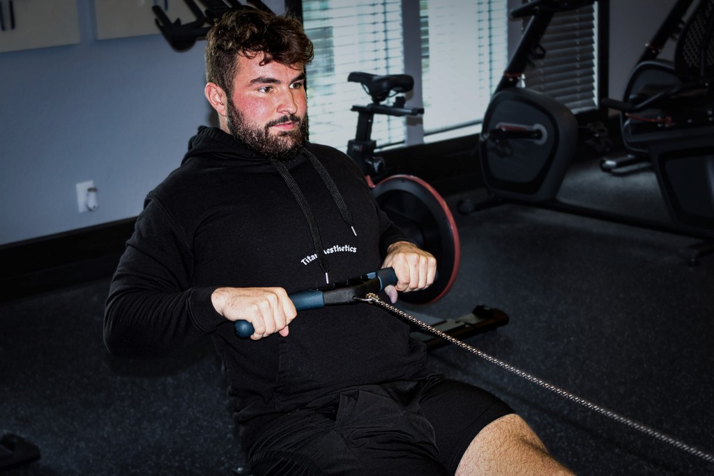 Man doing rows on a rowing cable machine for personal fitness.