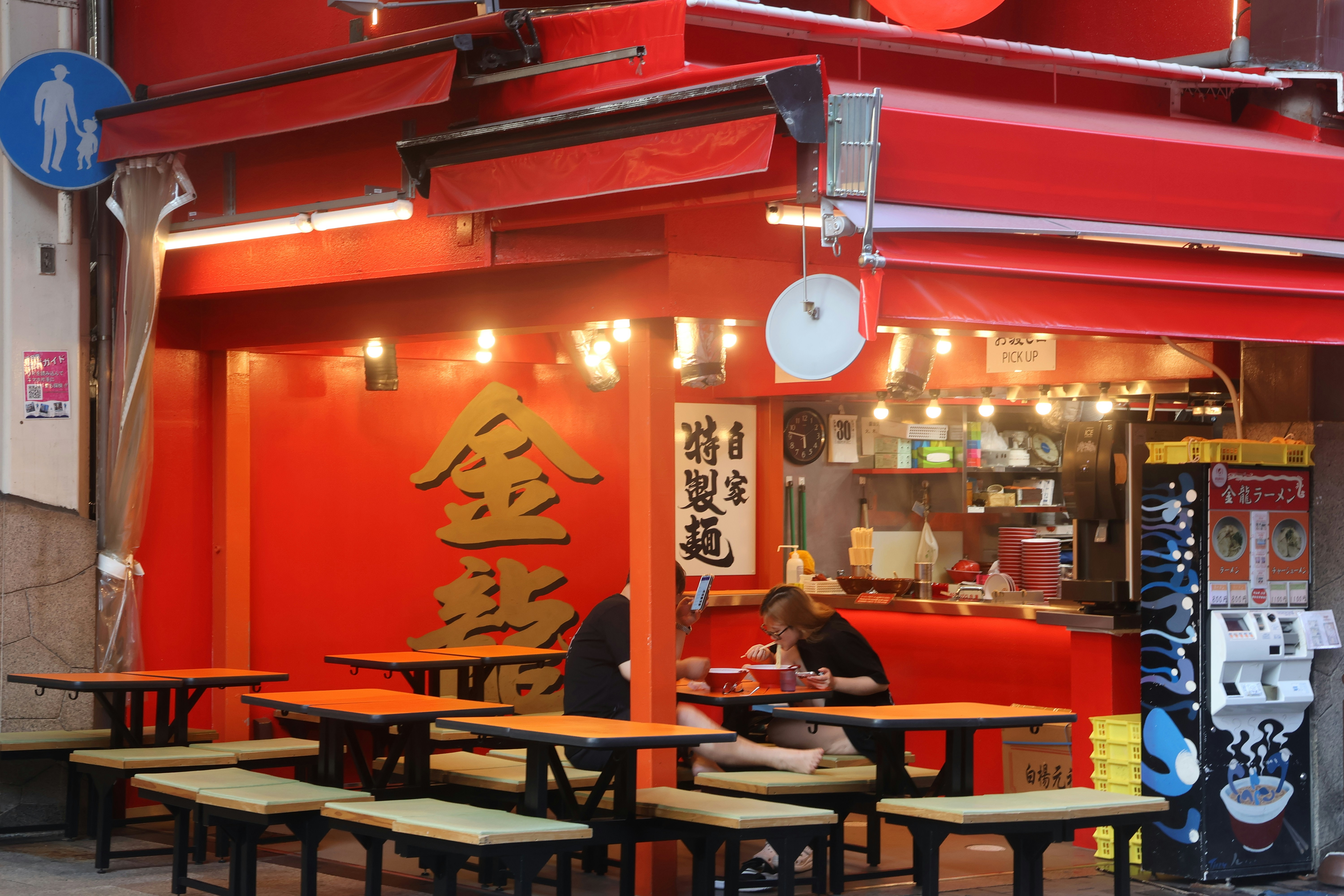 A restaurant with red walls and tables and chairs