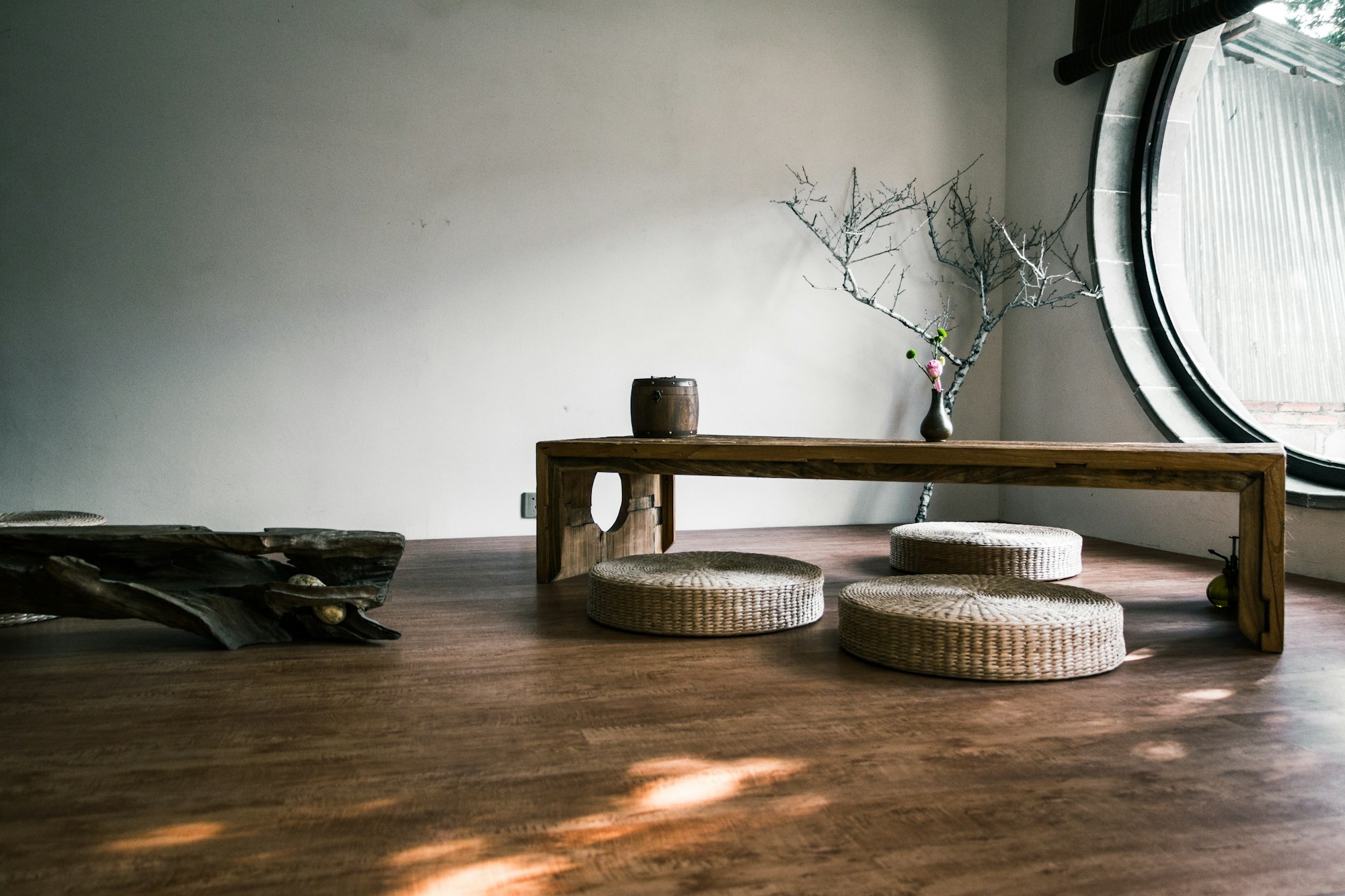 A low wooden bench beside a round window in a quiet room