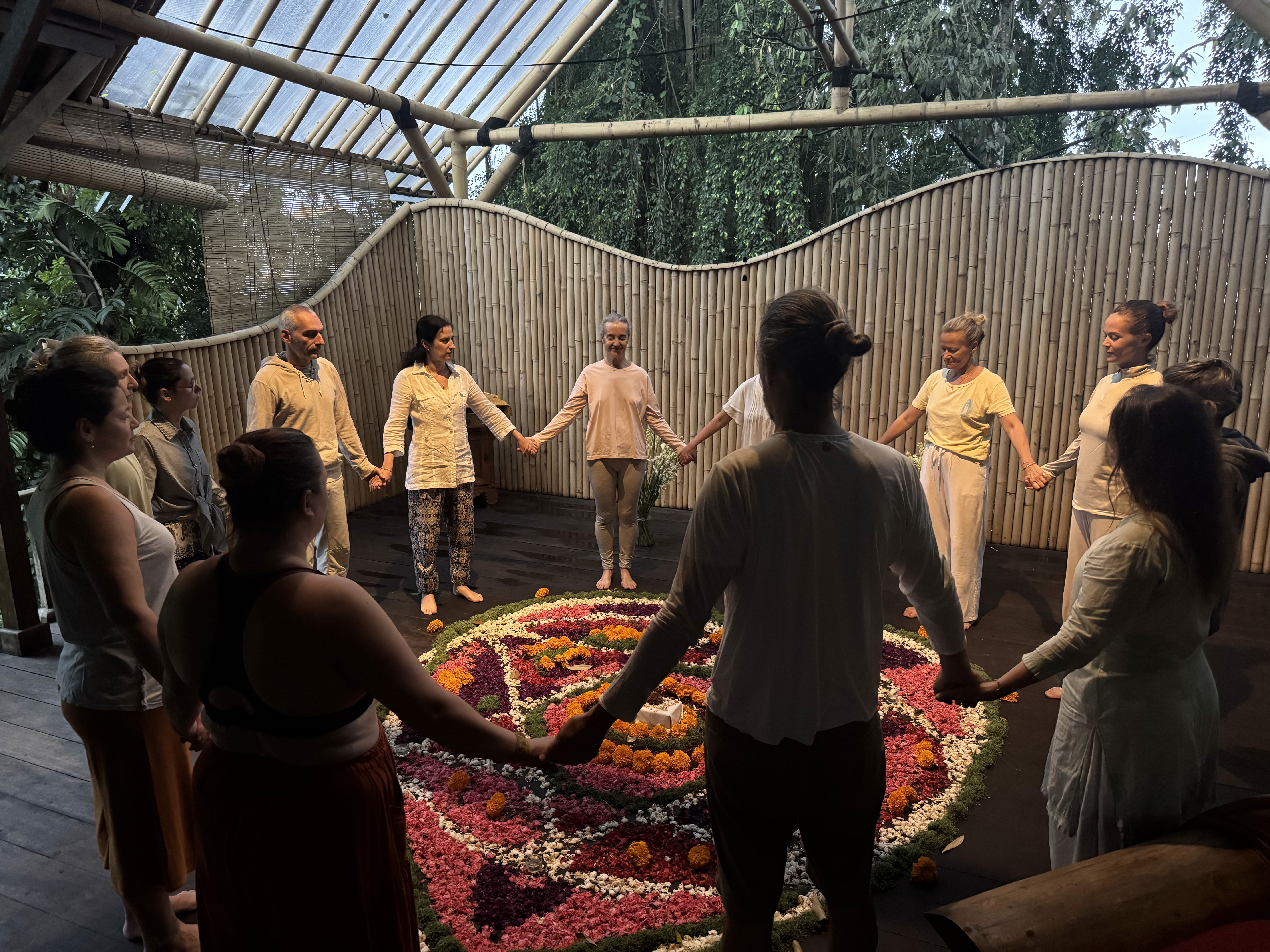 Plusieurs personnes debout se tenant la main en cercle.