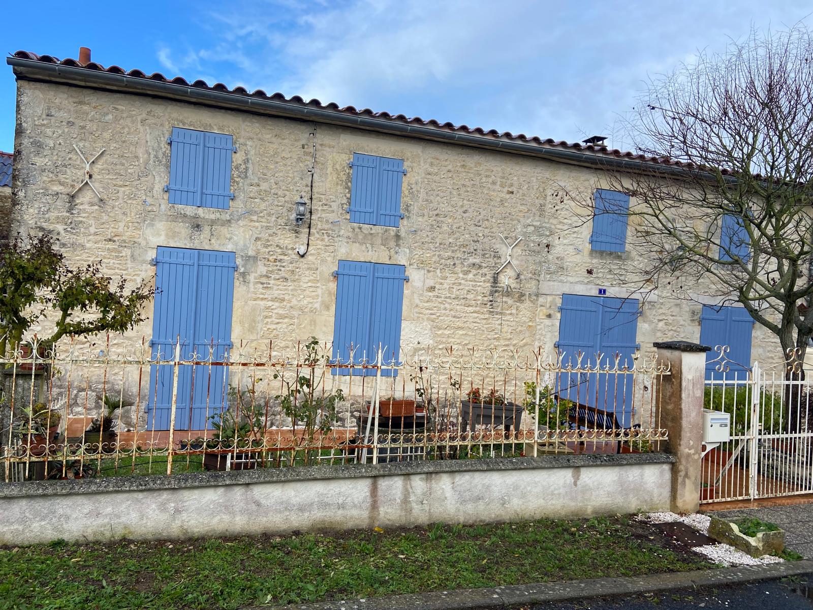 Couvreur nettoyant une gouttière remplie de feuilles mortes sur un pavillon nantais