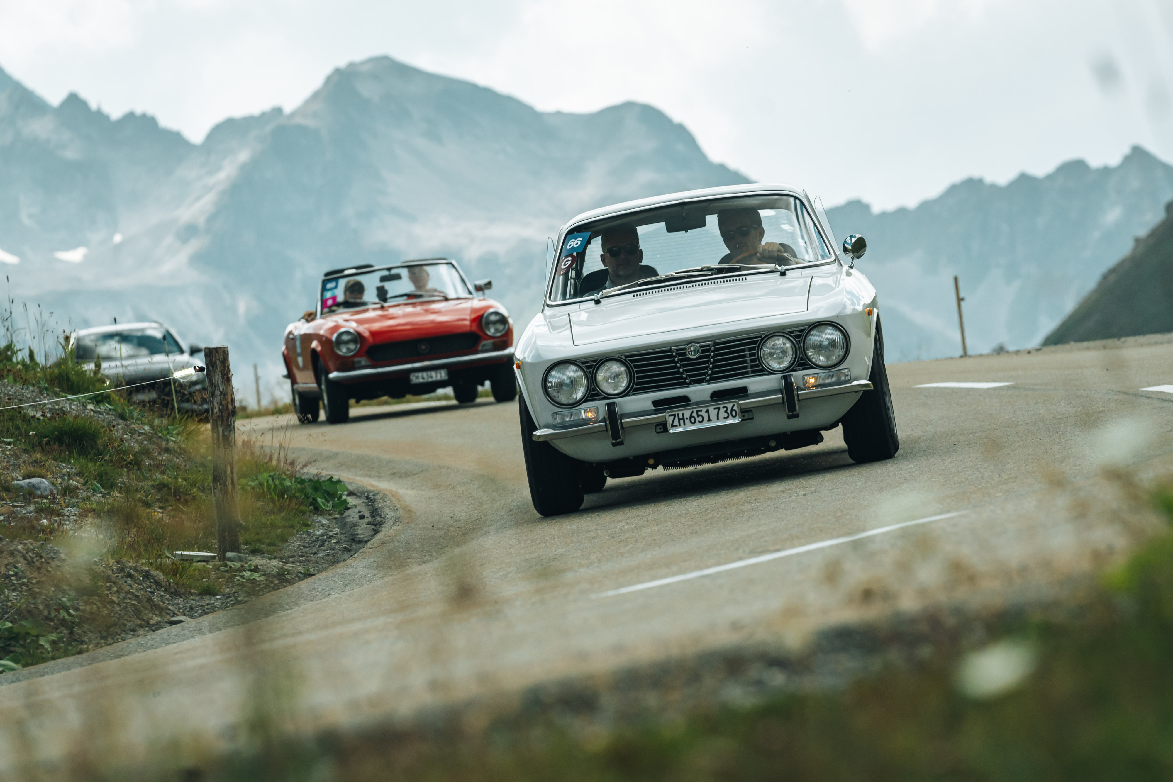 lancia fulvia e mg cabrio con panorama montagna