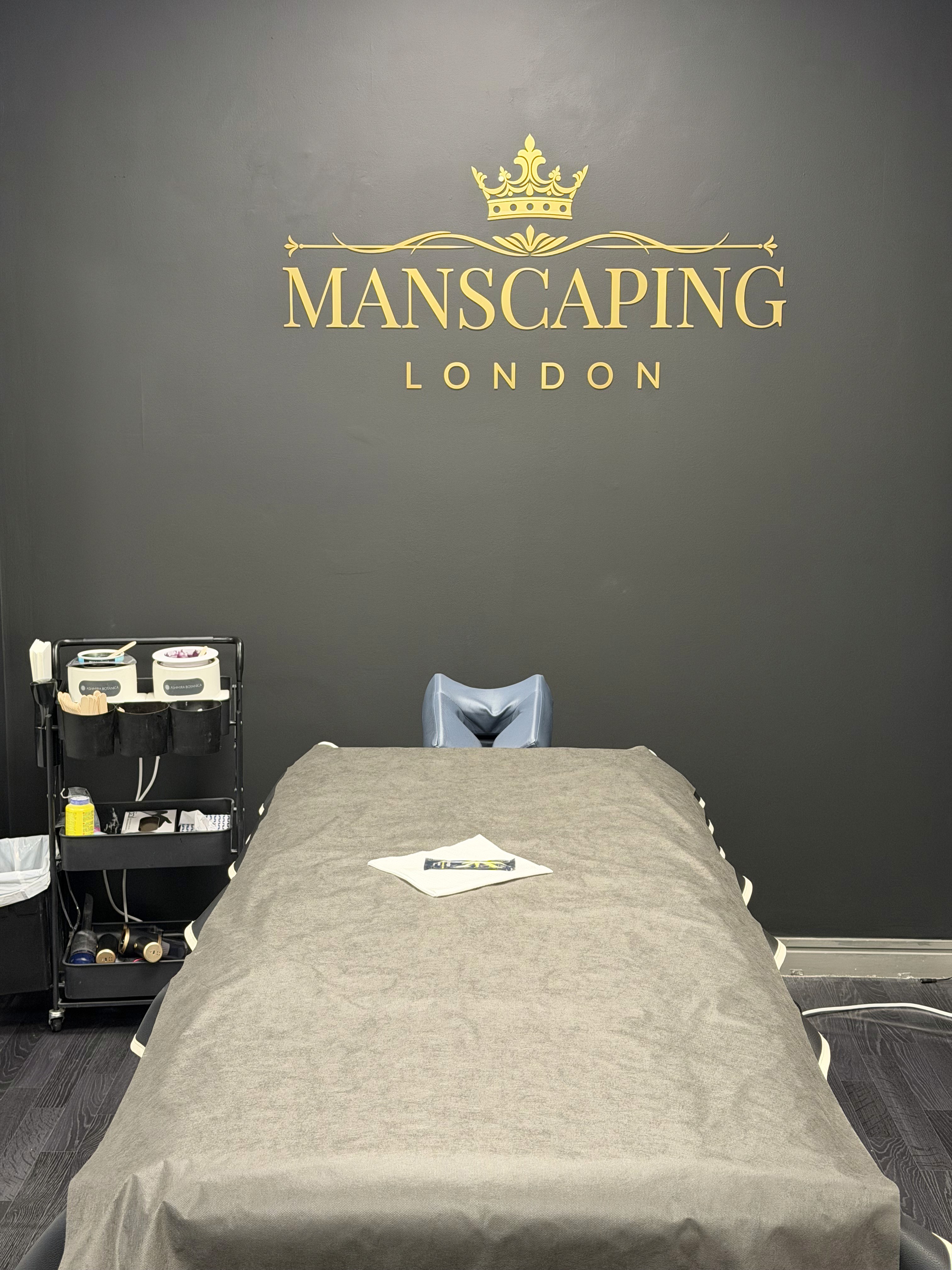 Picture of manscaping treatments table, showcasing the golden logo on the wall