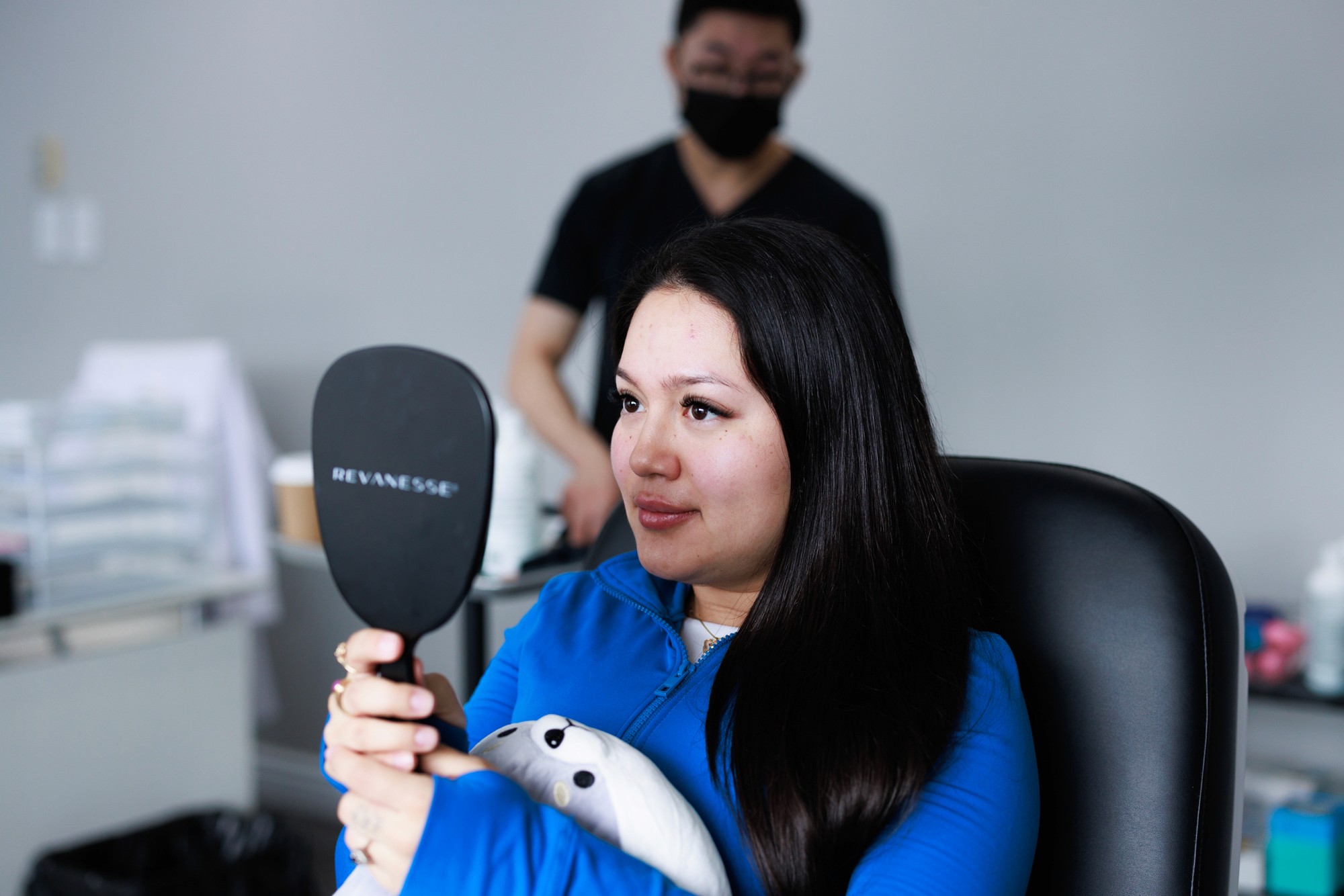 Patient looking at herself in the mirror following the treatment