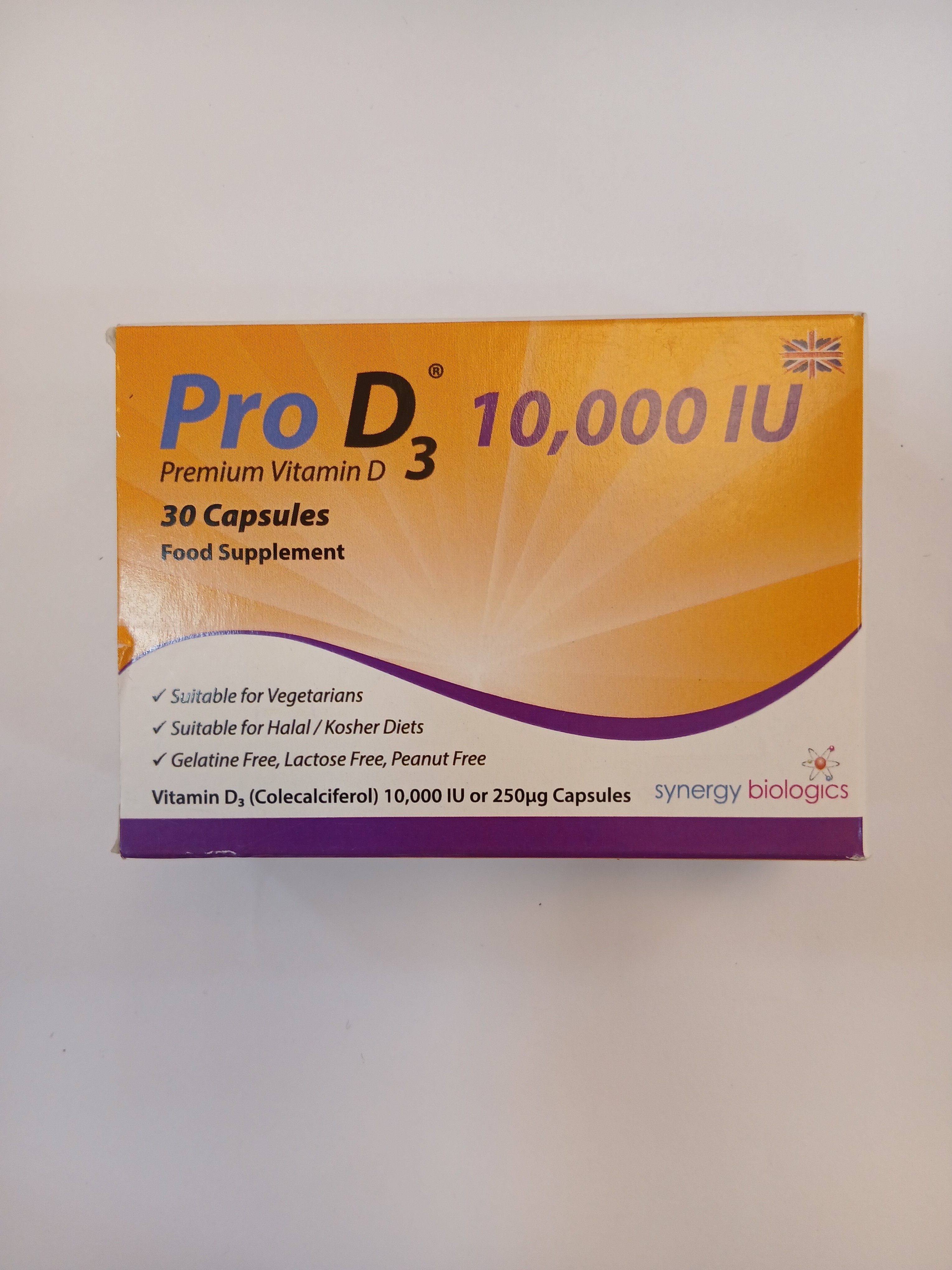 An orange and white cardboard box packaging contains 30 capsules of a food supplement, featuring printed text in black and green detailing vitamin D3 content and suitability information.