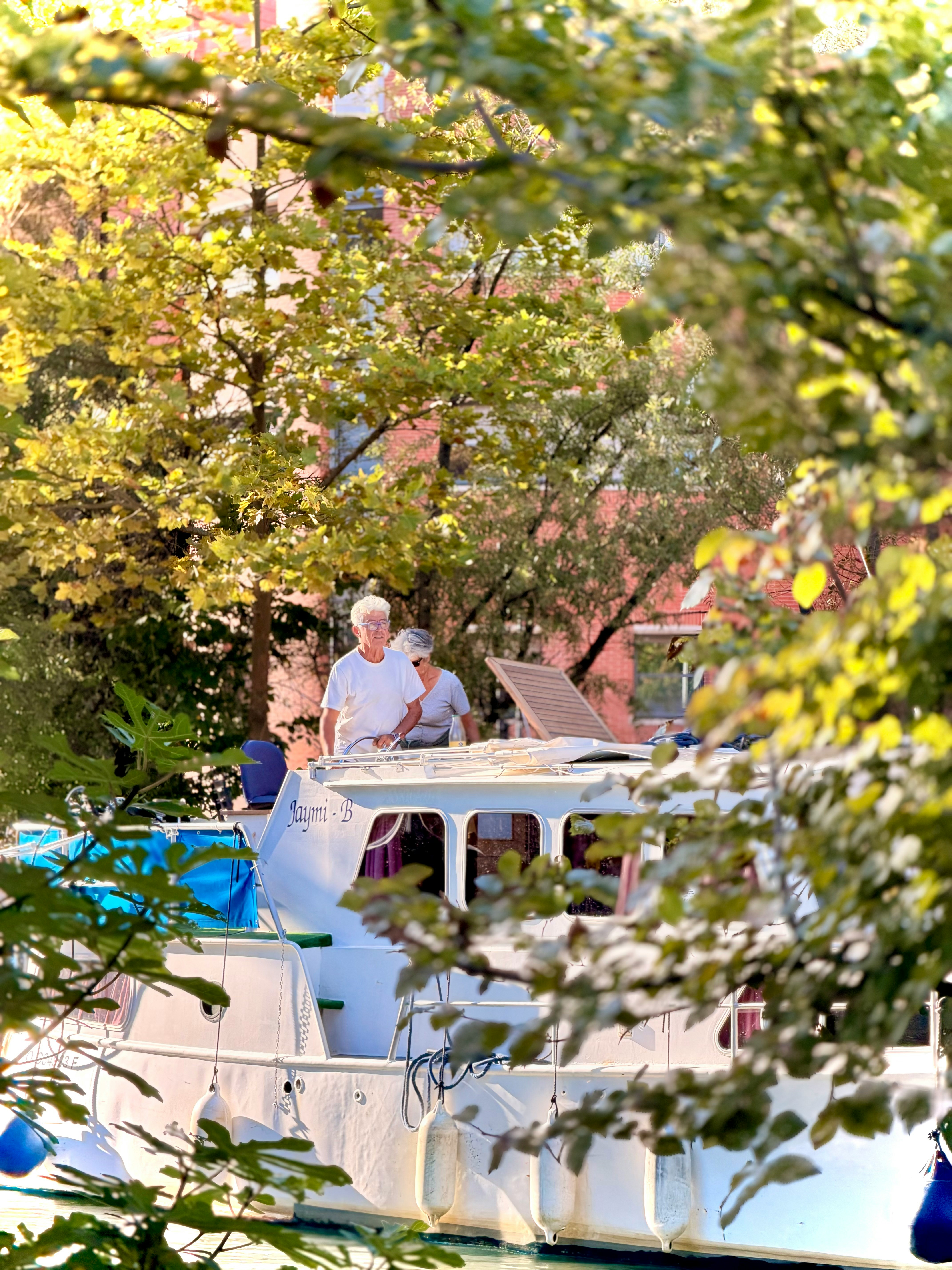 Two people on a boat surrounded by trees
