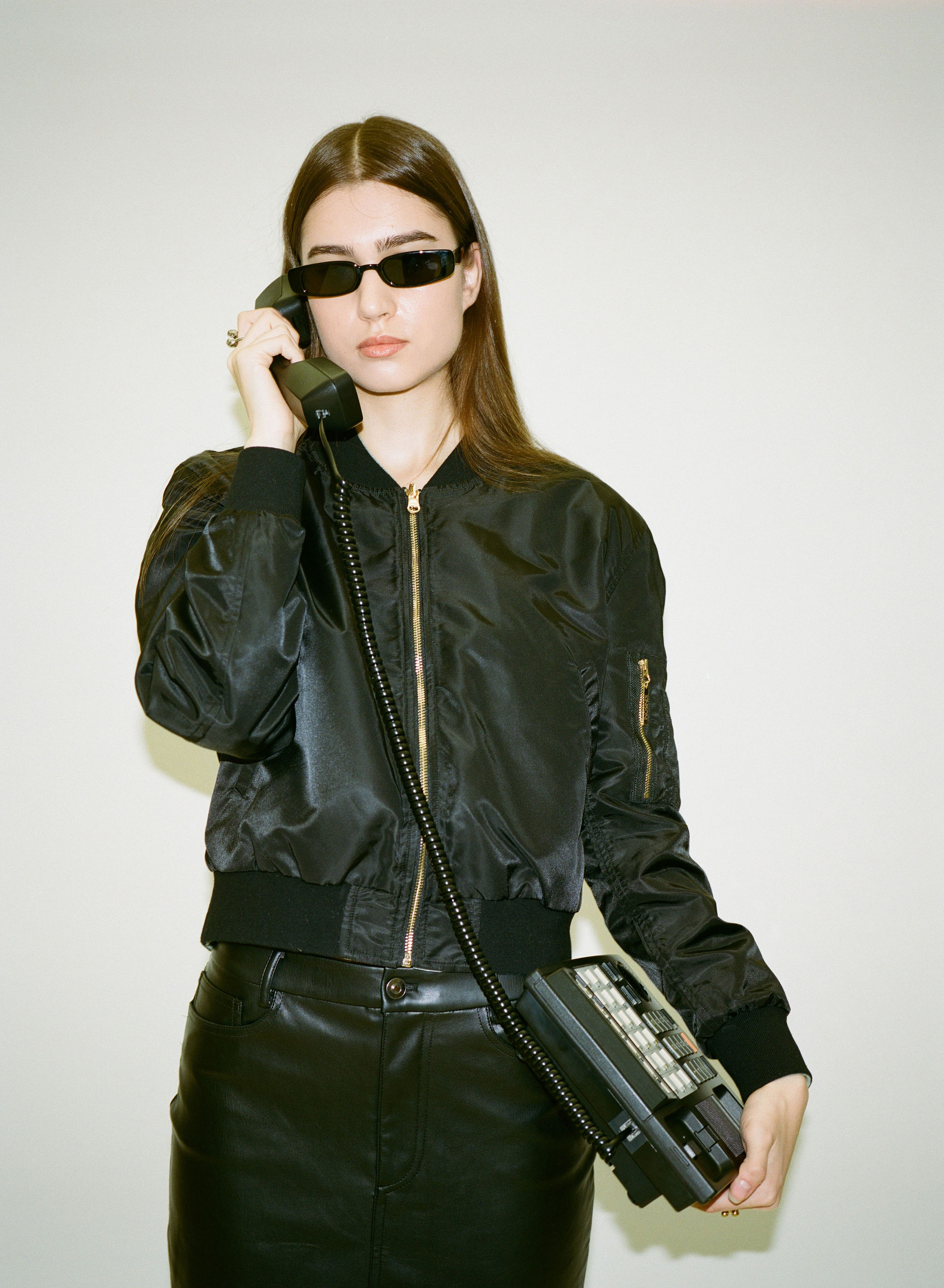 Young woman with dark hair and bangs, wearing red.