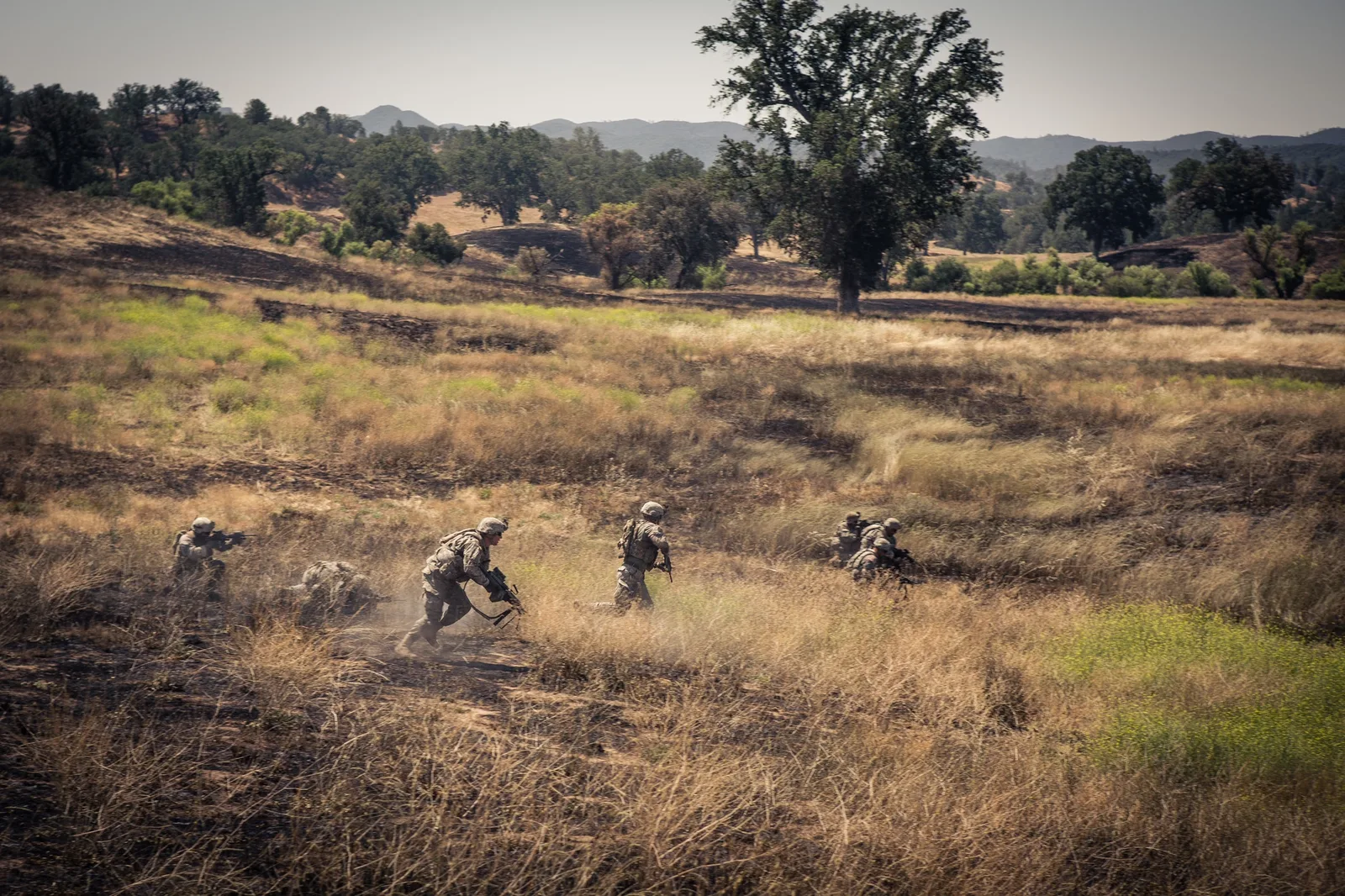 Infantrymen of 1-160th Infantry bound across open ground while another element suppresses during a platoon live fire at Fort Hunter Liggett