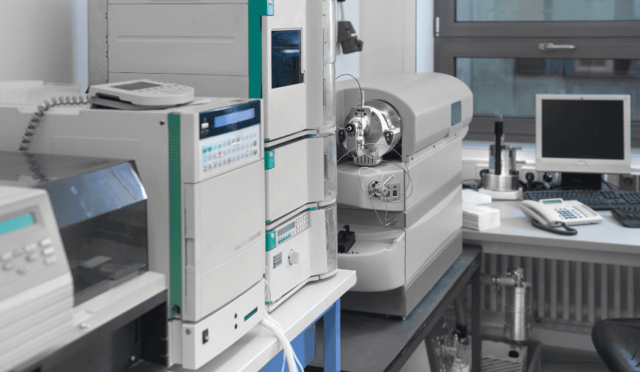 Gloved hands checking vials on a pharmaceutical filling line