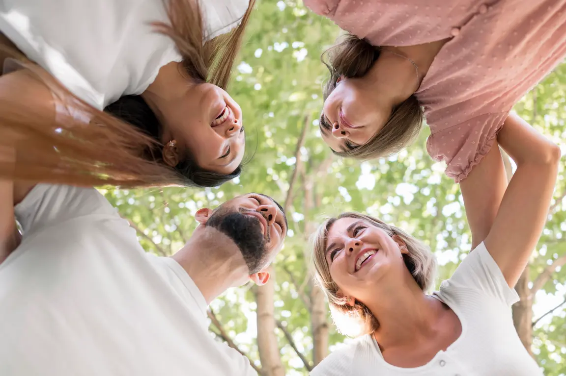 vue de dessous d'un groupe de personne qui se regarde en souriant