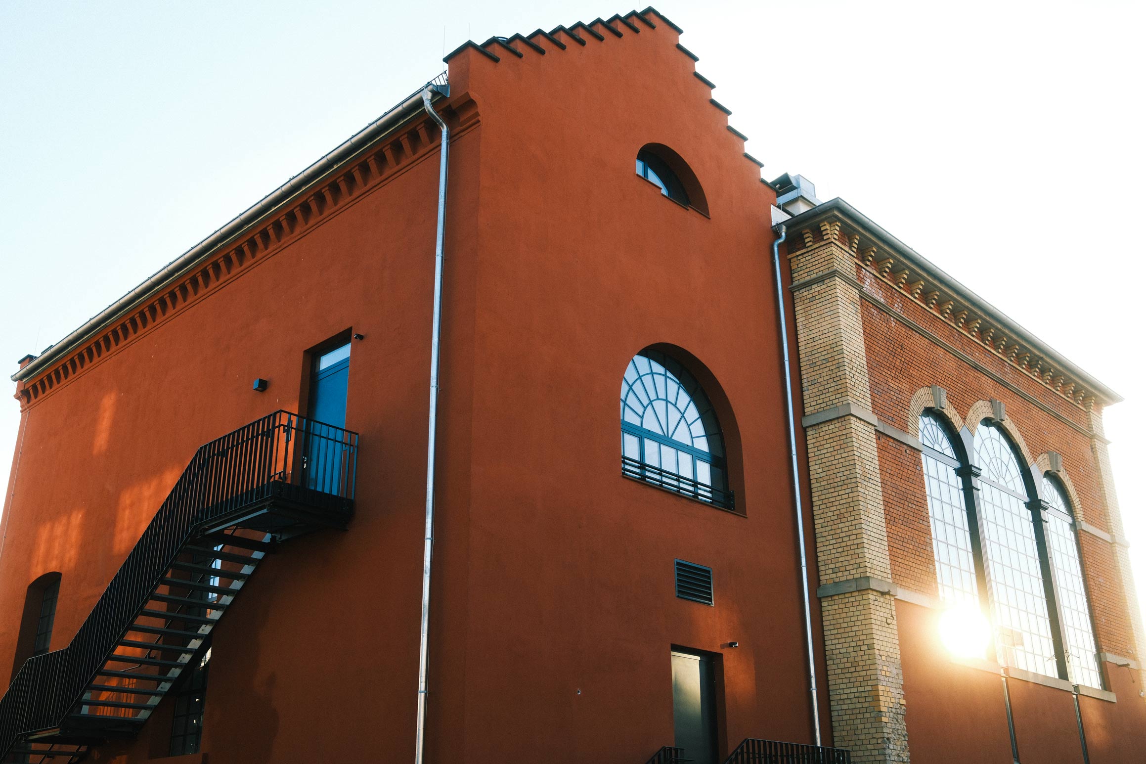 Four diverse professionals collaboratively working on a laptop, with one person pointing at the screen while others observe.