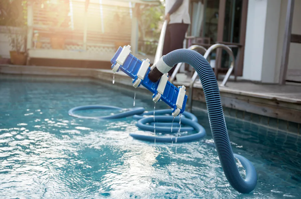 Automatic pool cleaner vacuuming a residential pool with water splashing around it.