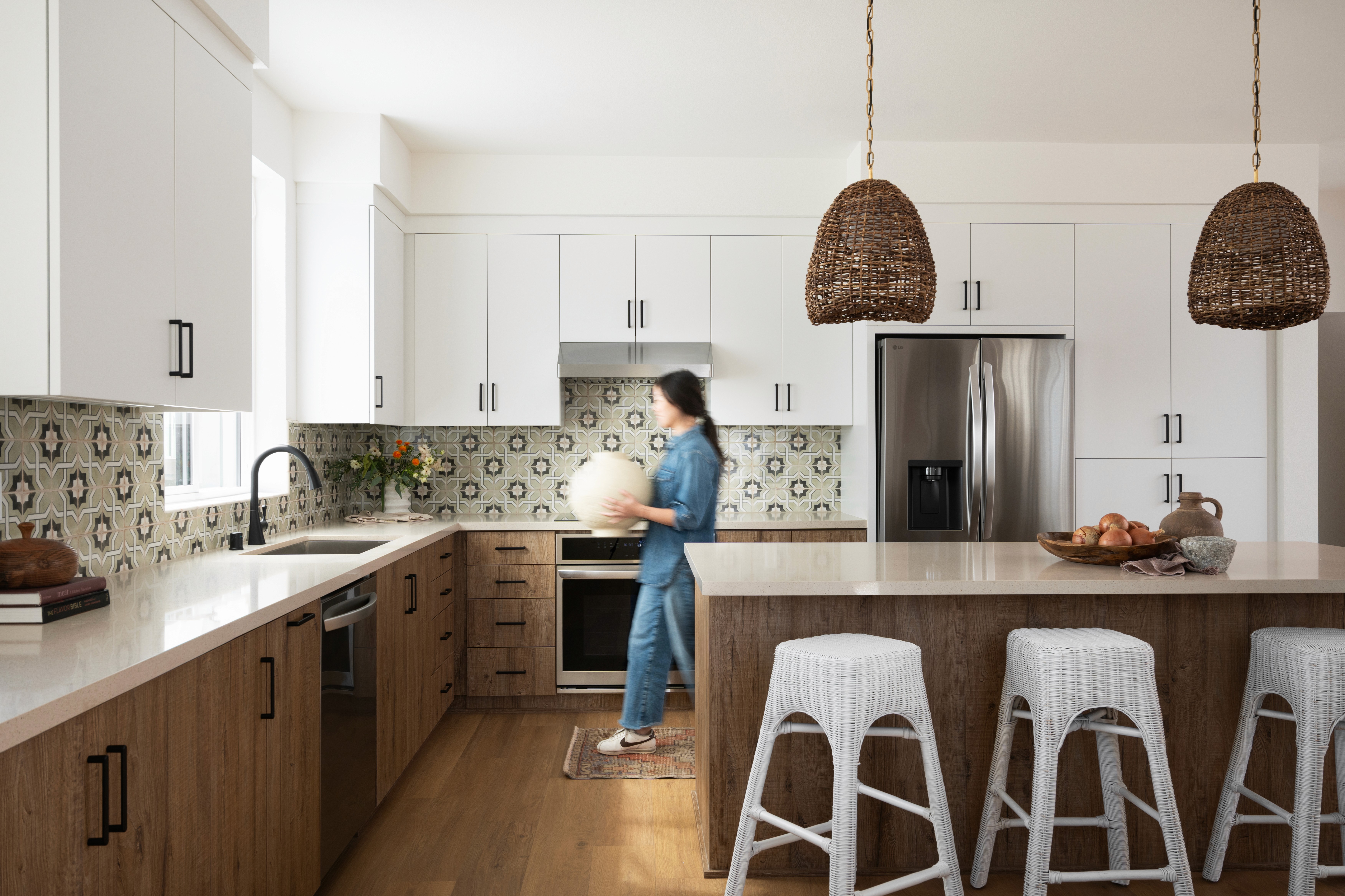 Kitchen with pendant lighting with person carrying vessel