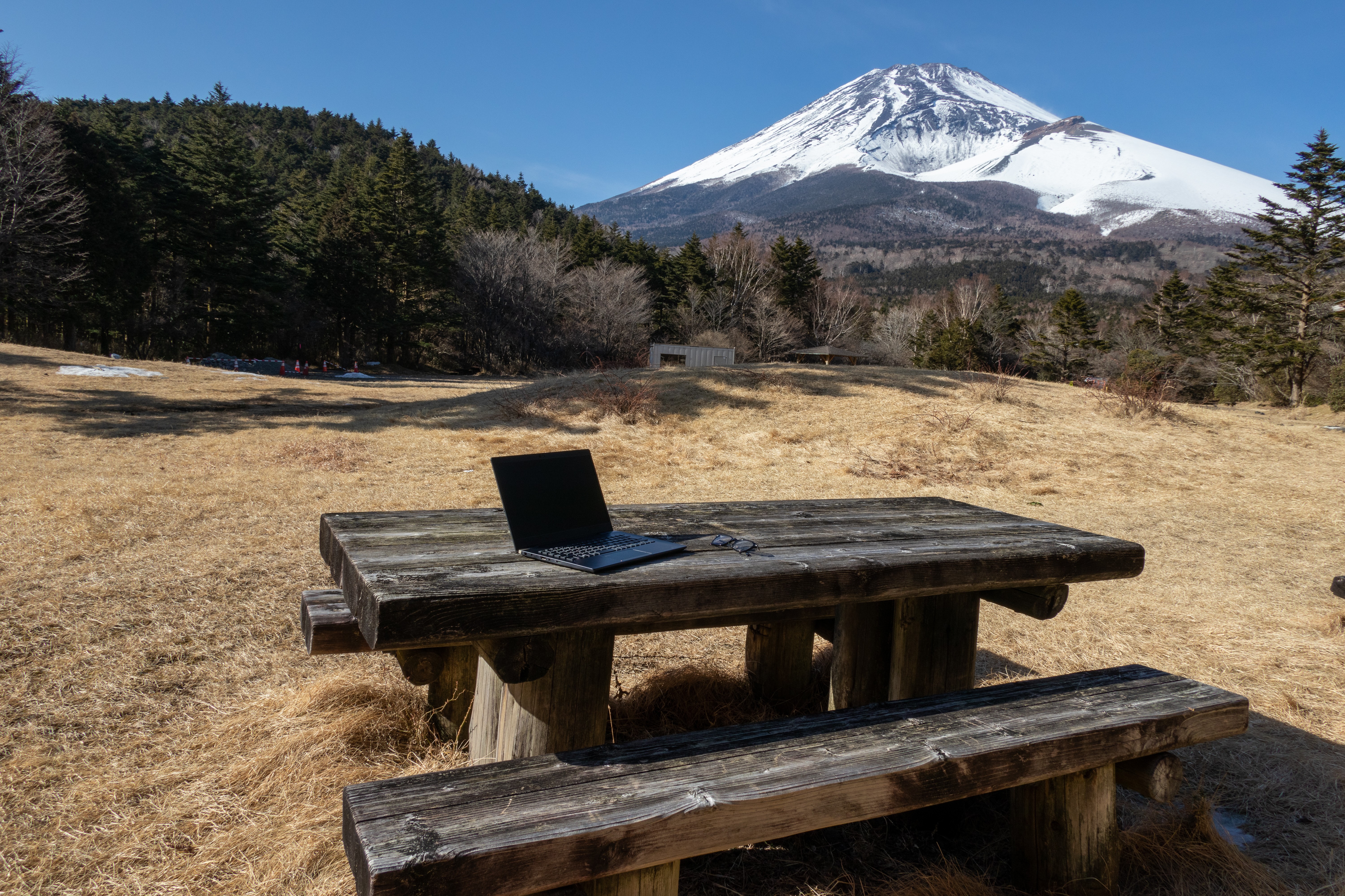 Three people sitting on a couch in a room looking at mobile devices