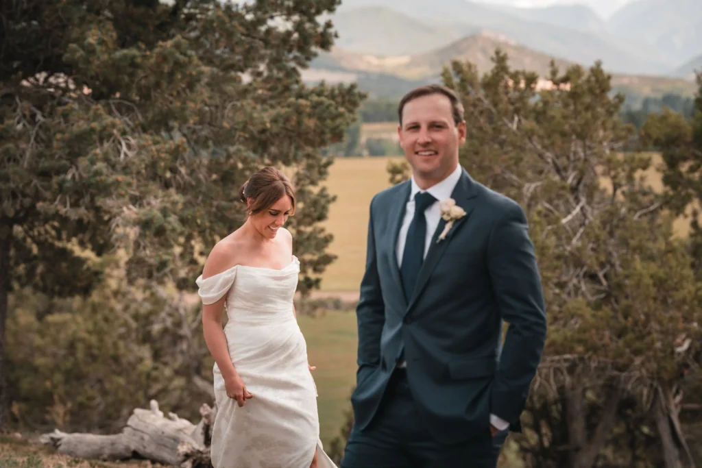 Newlyweds walking through a wooded mountain landscape
