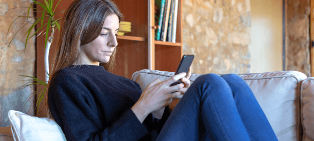 Beginner investor sitting on couch and navigating phone